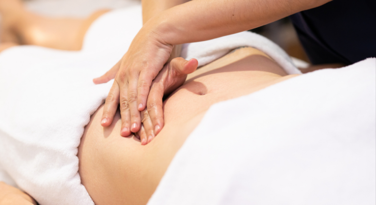 Person receiving a navel oiling massage for digestive balance and naabhi wellness, using Ayurvedic techniques on the abdomen.